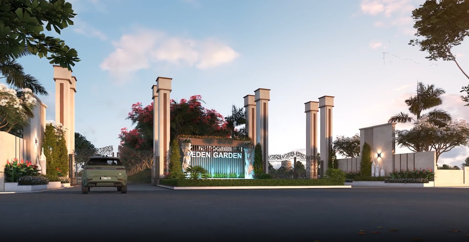 The gated entrance to Eden Garden in Ambamoliya, its name lit between tall stone columns with landscaped planting either side of the approach road.